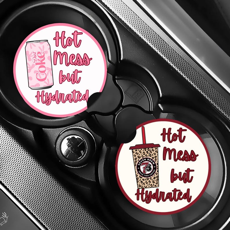 May include: Two car coasters with the text "Hot Mess but Hydrated". One coaster features a pink Diet Coke can, the other a leopard print coffee cup. Both coasters have a white background and a pink or maroon border.