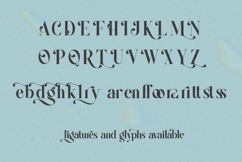 May include: A complete alphabet in a serif font, with decorative flourishes. The letters are dark gray against a light blue background. The text "ligatures and glyphs available" is at the bottom.