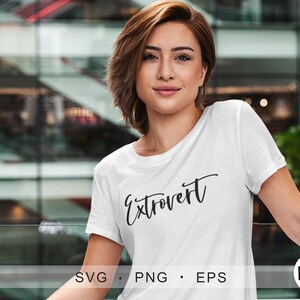 Op de afbeelding: Een wit T-shirt met het woord "Extrovert" in zwarte cursieve letters.