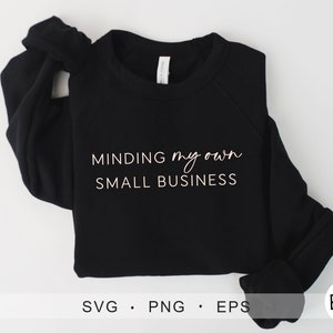 以下が含まれることがあります： 白い文字で「MINDING my own SMALL BUSINESS」と書かれた黒いスウェットシャツ