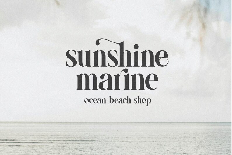 May include: A logo with the words "sunshine marine" in a dark gray, elegant font. Below, the text "ocean beach shop" is in a smaller, lighter font. The background is a soft, neutral color with a blurred image of the ocean.