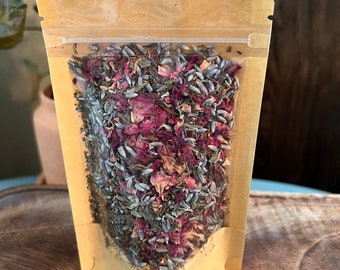 May include: A brown paper pouch with a clear plastic window, filled with dried lavender flowers and rose petals.