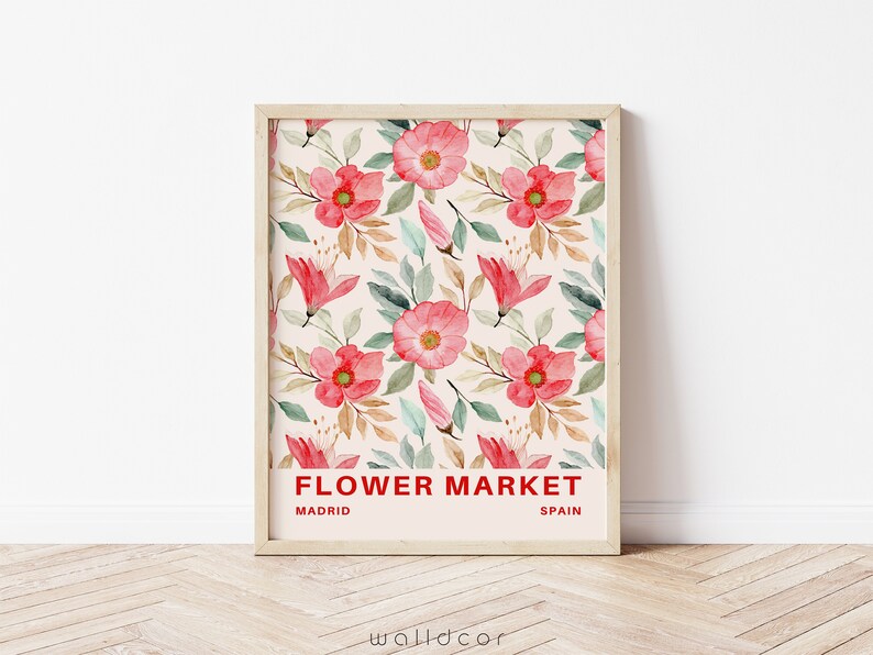 May include: A framed print with a watercolor floral pattern in shades of pink and green. The print has the text "FLOWER MARKET" in red, with "MADRID" and "SPAIN" below it.