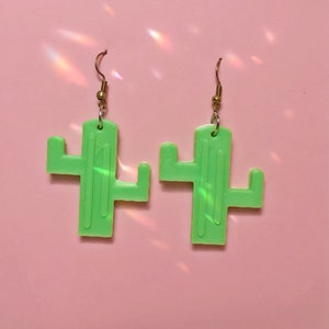 May include: A pair of green cactus-shaped earrings with gold hooks.