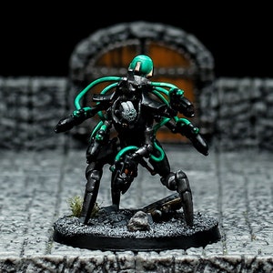 May include: A black and green painted miniature robot with multiple legs and a green head. The robot is posed in a dynamic action pose with its legs spread out and its arms raised. The robot is standing on a black base.