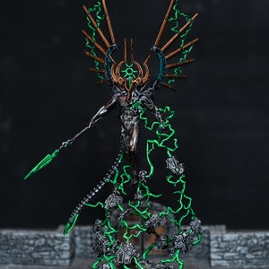 May include: A detailed miniature figure of a skeletal being with metallic wings and green energy flowing around it. The figure is holding a spear and is standing on a base with debris.