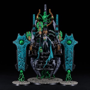 May include: A detailed miniature of a dark, skeletal figure in a green robe, sitting on a throne with a black and gold design. The throne is surrounded by green and gold details, and the figure is holding a staff with a green orb at the top. The figure is flanked by two large, green and blue shields with green gems.