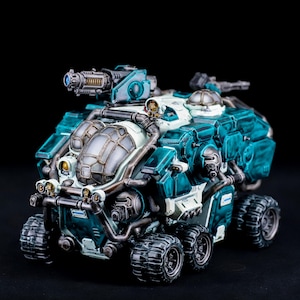 Könnte beinhalten: Ein detailliertes Modell eines futuristischen Fahrzeugs in Teal und Weiß mit einem großen Geschütz auf dem Dach und mehreren Rädern.