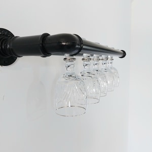 Può includere: Porta bicchieri da vino in metallo nero con cinque bicchieri di vetro trasparente appesi.