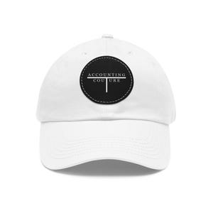 May include: White baseball cap with a black circle patch that says "ACCOUNTING COUTURE" in white text.