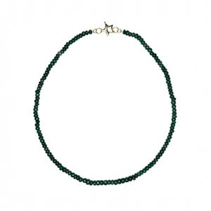 Puede incluir: Un collar de cuentas verde oscuro con un cierre dorado en forma de estrella. El collar está compuesto por pequeñas cuentas redondas y se muestra sobre un fondo blanco. Las cuentas son de un color verde esmeralda intenso.