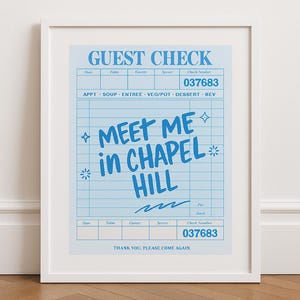 Könnte beinhalten: Ein gerahmter Druck mit einem hellblauen Scheckdesign. Der Text "GUEST CHECK" steht oben, mit Feldern für Datum, Tisch, Gäste, Kellner und Schecknummer. Der Satz "MEET ME in CHAPEL HILL" ist deutlich sichtbar.