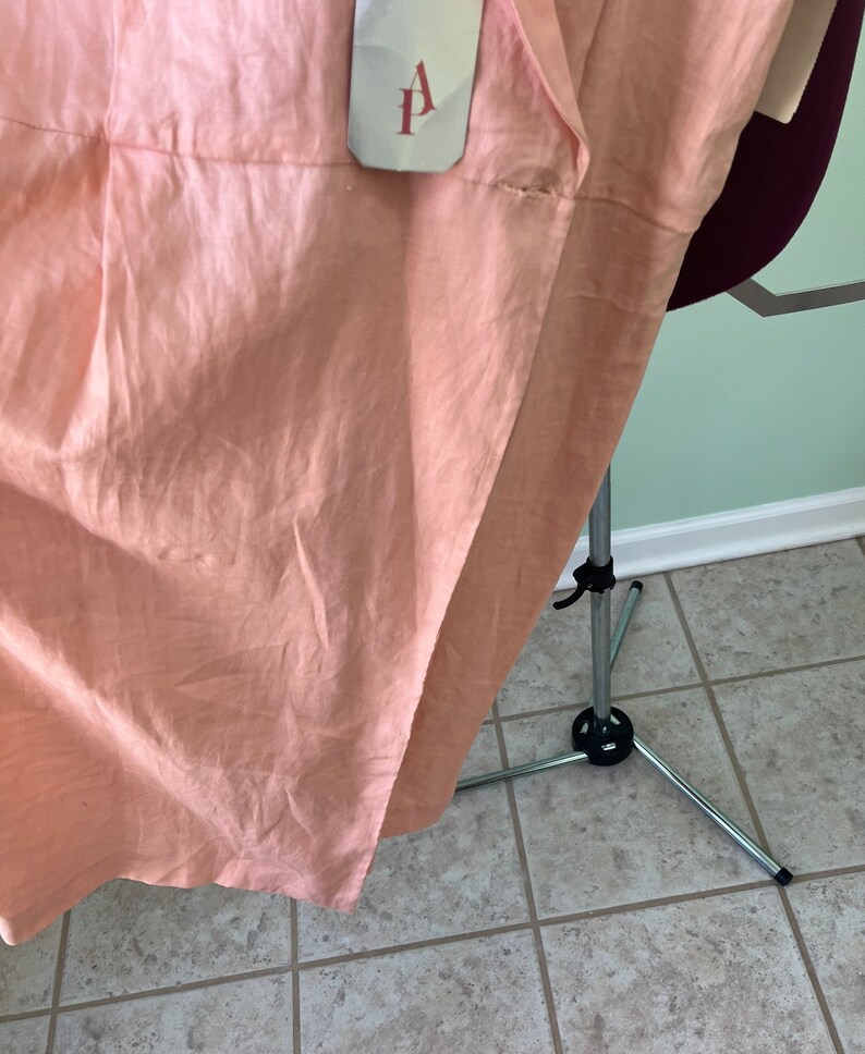 May include: A peach-colored linen dress with a white tag that says "A.P." on it.