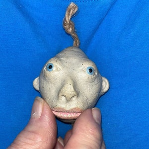 Headhunter with blue eyes and sharp teeth hand molded out of ceramics man eater people-eater anthropology Shrunken head replica