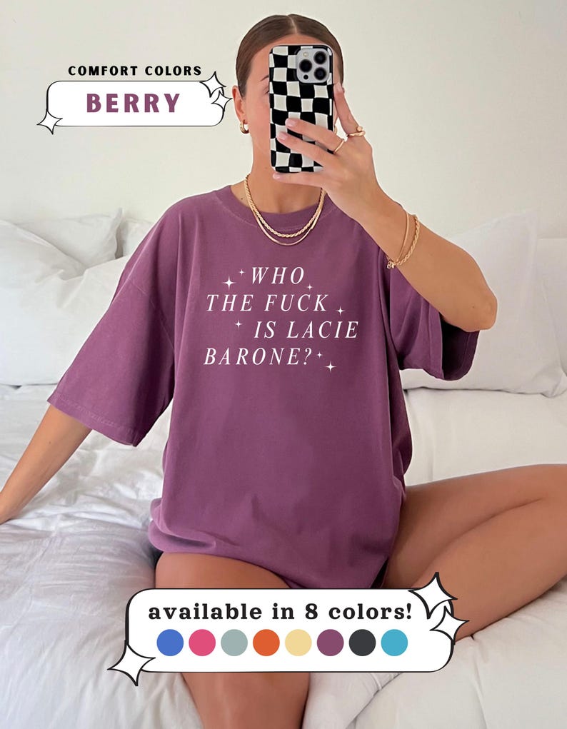 May include: Berry-colored t-shirt with the text "WHO THE FUCK IS LACIE BARONE?" in white. The shirt is part of the Comfort Colors collection and is available in 8 colors. The image shows a person wearing the shirt.