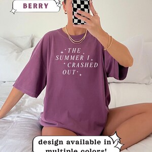 Pode incluir: T-shirt cor de baga com o texto branco "THE SUMMER I CRASHED OUT". A camisa faz parte da cole&ccedil;&atilde;o Comfort Colors. O design est&aacute; dispon&iacute;vel em v&aacute;rias cores.