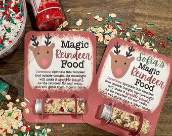 May include: Two red and white Christmas cards with a reindeer illustration and the text "Magic Reindeer Food". Each card has a small glass vial filled with colorful sprinkles and oats.