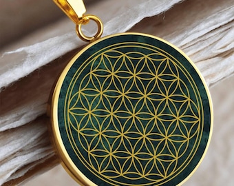 May include: Gold necklace with a round pendant featuring a green and gold flower of life design.