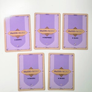 Back side of the five player cards with a light purple background and a golden border. Each card has the text "PLAYER CARDS" and the name of the respective FlyQuest 2025 player: BWIPO, INSPIRED, QUAD, MASSU, and BUSIO. The cards also have the year "2025" and the artist's signature.