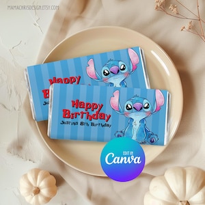 May include: Two candy bar wrappers with a blue vertical striped background and a cartoon character. The wrappers say "Happy Birthday" in red text and "Justin's 8th Birthday". The wrappers are on a beige plate.