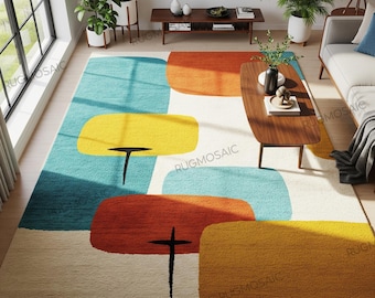 May include: A large area rug with a mid-century modern design. The rug features large, colorful, abstract shapes in shades of blue, yellow, orange, and beige. Black lines create the stems of the shapes. The rug is placed in a living room setting.