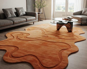 May include: A large, abstract, orange-colored rug with a wavy, organic shape. The rug is in a living room setting with a glass coffee table and two sofas.