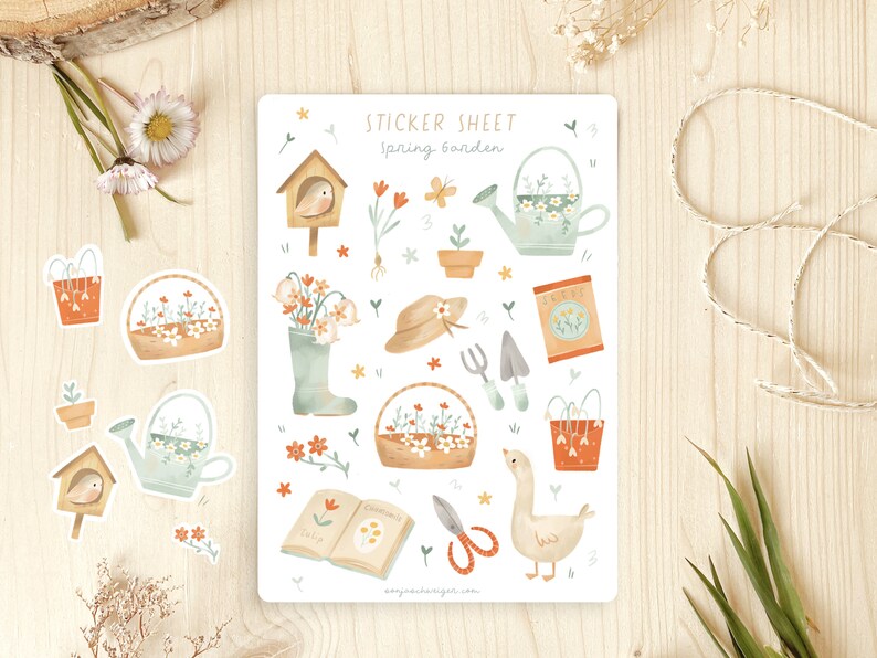May include: A sticker sheet with a spring garden theme. The sheet features illustrations of a birdhouse, watering can, flowers, gardening tools, a goose, and the text "Spring Garden". The stickers are in soft pastel colours.