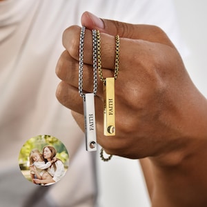 Peut inclure: Deux colliers en argent avec une barre gravée du mot "FAITH". L'un a une chaîne dorée et l'autre une chaîne argentée.