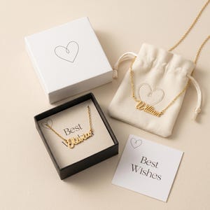 Peut inclure: Colliers dor&eacute;s avec des noms, pr&eacute;sent&eacute;s dans une bo&icirc;te noire, une bo&icirc;te cadeau blanche et une pochette &agrave; cordon. Les colliers sont personnalis&eacute;s avec les noms "William" et "Olivia". Une carte "Best Wishes" est &eacute;galement pr&eacute;sente.