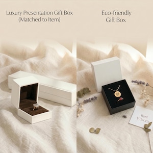 May include: A white rectangular luxury presentation gift box with a brown interior containing a ring, and a white square eco-friendly gift box with a black interior containing a gold necklace and a ring, accompanied by a card reading Best Wishes.