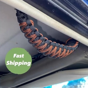 May include: A black and brown braided rope handle for a car. The handle is attached to the roof of the car. The text "Fast Shipping" is visible in the image.