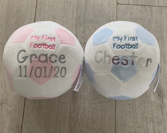 May include: Two plush footballs, one pink and white with the text "My First Football Grace 11/01/20" and the other blue and white with the text "My First Football Chester".