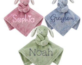 May include: Three plush bunny security blankets in pink, blue, and green with embroidered names "Sophia", "Grayson", and "Noah".