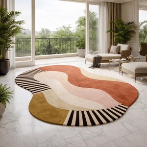 May include: An abstract area rug with a unique, organic shape. The rug features a color palette of rust, beige, pink, and brown, with black and white striped accents. The rug is placed on a white tiled floor.