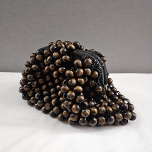 May include: A brown wooden beaded purse with a black zipper closure.