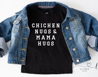 May include: Black t-shirt with white text that reads "Chicken Nugs & Mama Hugs". The shirt is layered over a blue denim jacket.