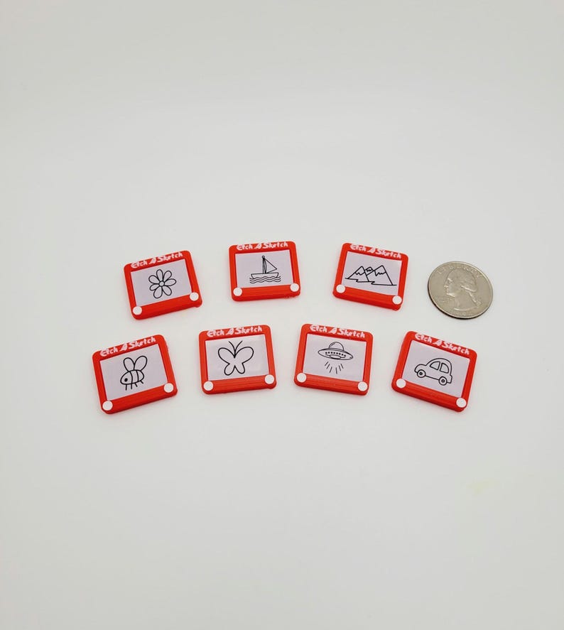 May include: Eight red Etch A Sketch toys with different drawings on the screen. The drawings include a flower, a sailboat, mountains, a bee, a butterfly, a UFO, and a car.