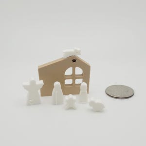 May include: A white nativity scene set with a brown wooden stable, a star on top, and figures of Mary, Joseph, a baby, an angel, and a sheep.