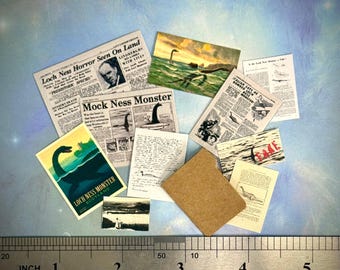 May include: Miniature ephemera featuring Loch Ness Monster illustrations and newspaper clippings. Includes a postcard with "Loch Ness Monster Scotland" text, and a ruler showing inches. A brown rectangle is also present.