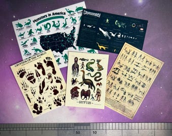 May include: A collection of miniature posters featuring cryptids and monsters. One poster displays a map of the United States with monster icons. Other posters include illustrations of cryptids and their footprints. A ruler is at the bottom.