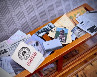 May include: A wooden display case filled with vintage ephemera, including newspaper clippings, photographs, and documents. The items have a retro aesthetic, with a focus on UFOs and classified information. A card with the word "CLASSIFIED" is visible.