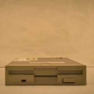 May include: A beige floppy disk drive with a black button on the front.