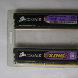 May include: Two black computer memory modules in a clear plastic package. The modules are labeled "CORSAIR" and "XMS2 DDR2 memory". The module on top has the text "CM2X1024-6400" and "XM56405v6.2 007389 07436008-0 5-6-8-12 800MHz 1024MB XM53-4400".