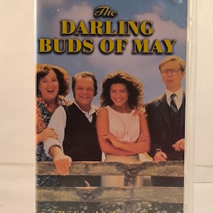 Pode incluir: Capa de cassete de vídeo VHS com um grupo de quatro pessoas, com o título "The Darling Buds of May" e o texto "The Complete First Series It's "Perfick!"  PG".