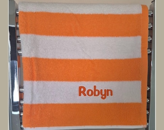 Personalised embroidered beach towel, kids swimming towel, made using 3d puff embroidery. Yellow, orange, green, blue, red and grey.