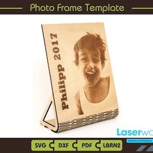 May include: A wooden photo frame template with a cutout design. The frame is designed to stand upright and features a slot for a photo. The frame is engraved with the text "Philipp 2017".