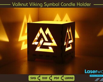 Può includere: Un portacandele in legno con un design geometrico a forma di Valknut, un simbolo della mitologia norrena. Il portacandele è acceso e proietta un bagliore caldo.