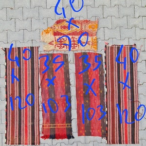 May include: Four vintage Turkish kilim rugs in red, black, and white with geometric patterns. The rugs are different sizes, with the largest measuring 40 inches by 90 inches.