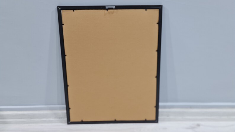 May include: A black picture frame with a brown mat. The frame is empty.
