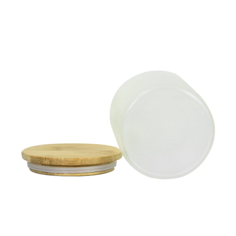 May include: A frosted glass jar with a bamboo lid and a silicone seal. The jar is empty and the lid is off.